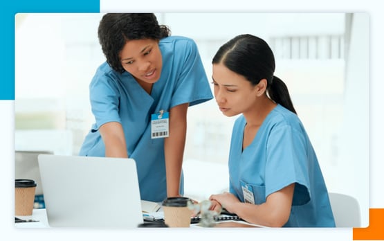 two female surgeons looking at a laptop